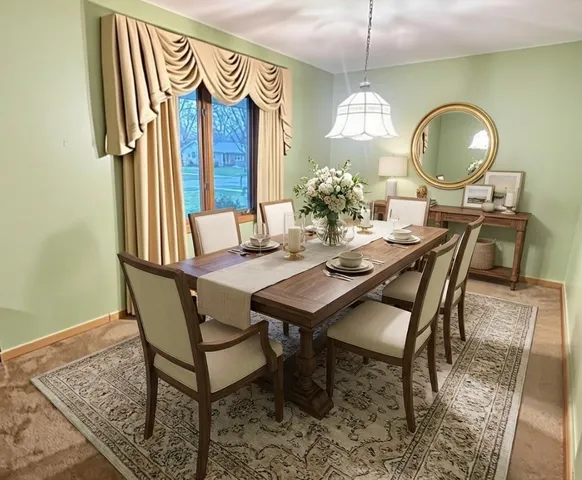 a dining room with wooden floor a chandelier a wooden table and chairs