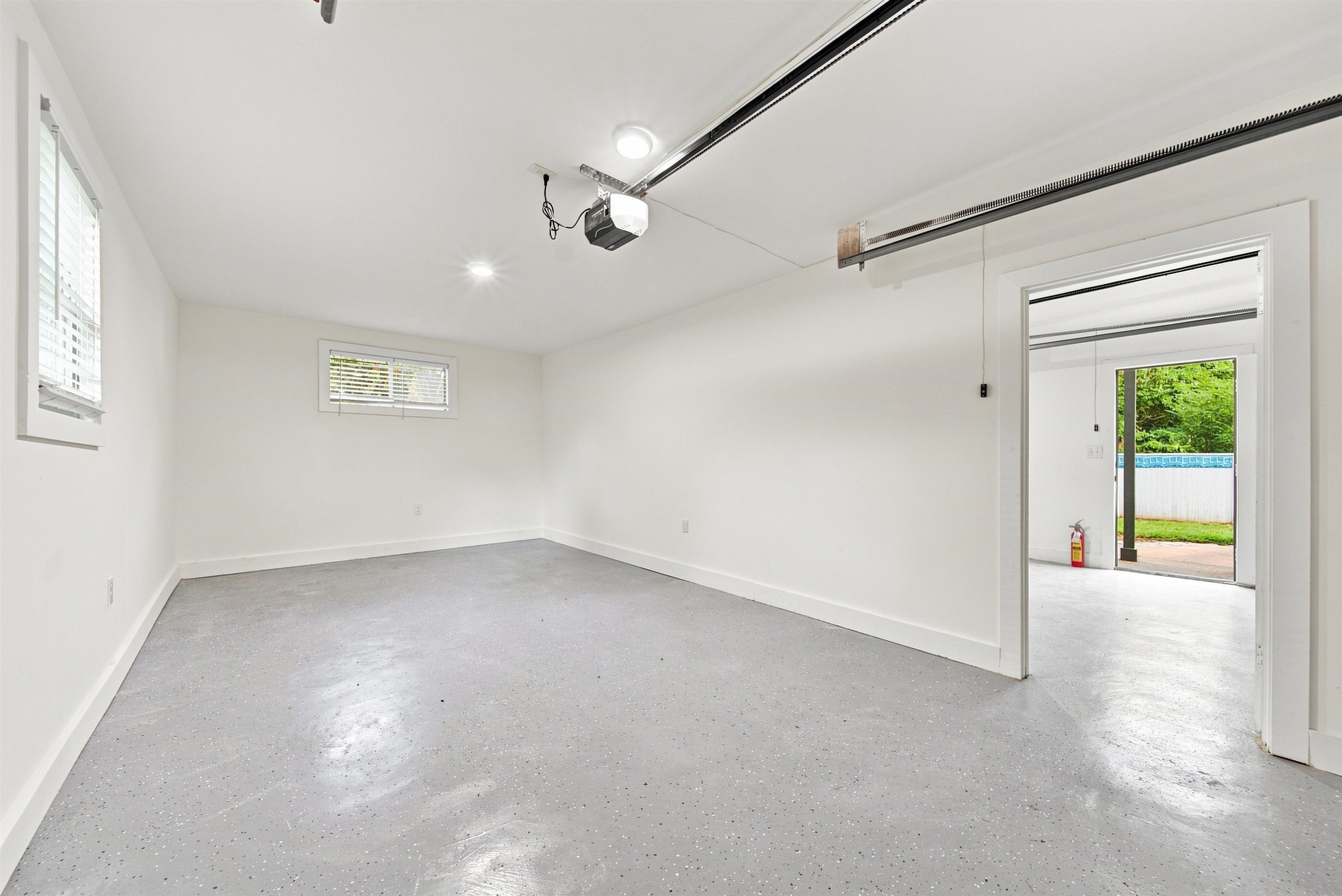 458 Gerald Road Memphis, TN 38122 - Photo 36 of 37 Finished garage space with an epoxy floor, track lighting, and a window with blinds