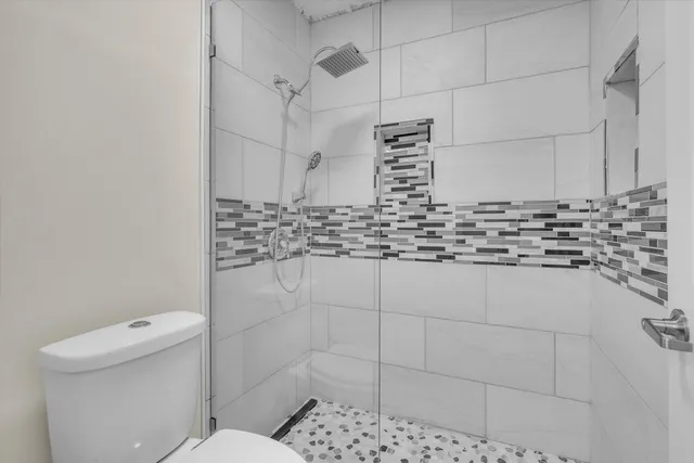 a bathroom with a toilet and a shower