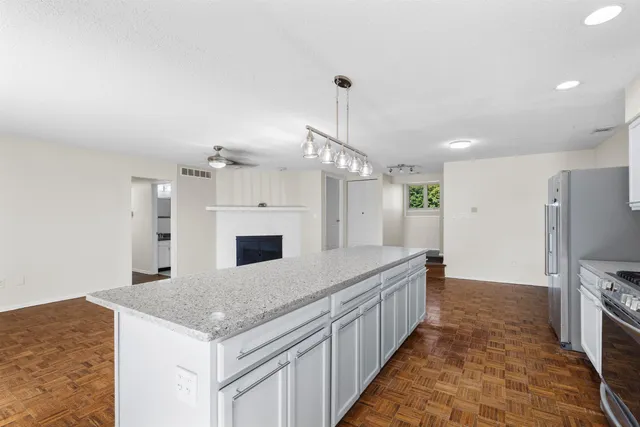 a kitchen with a sink a counter top space stainless steel appliances and a chandelier