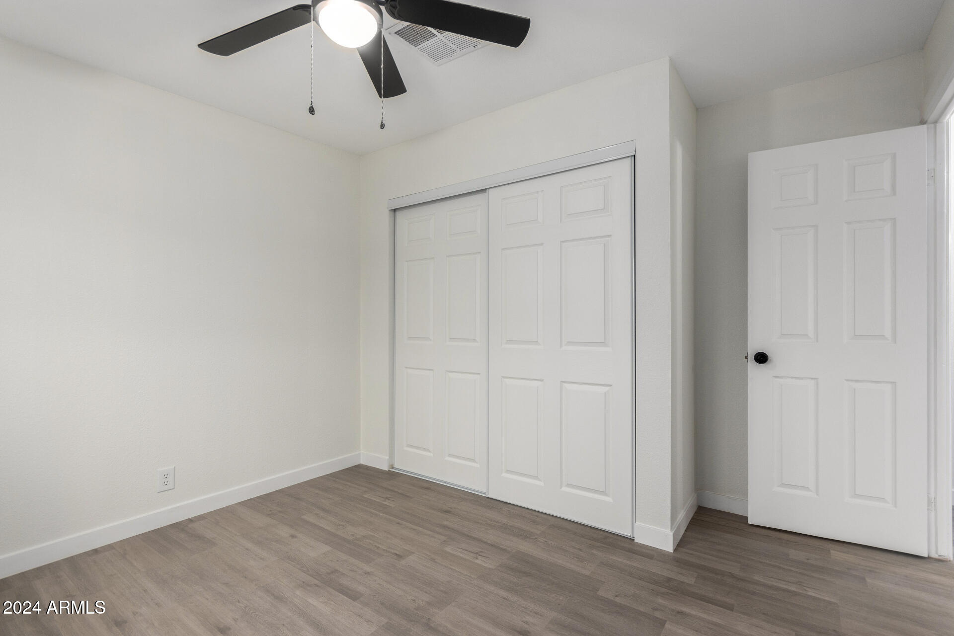 204 East Baseline Road Buckeye, AZ 85326 - Photo 19 of 29 an empty room with wooden floor closet and ceiling fan