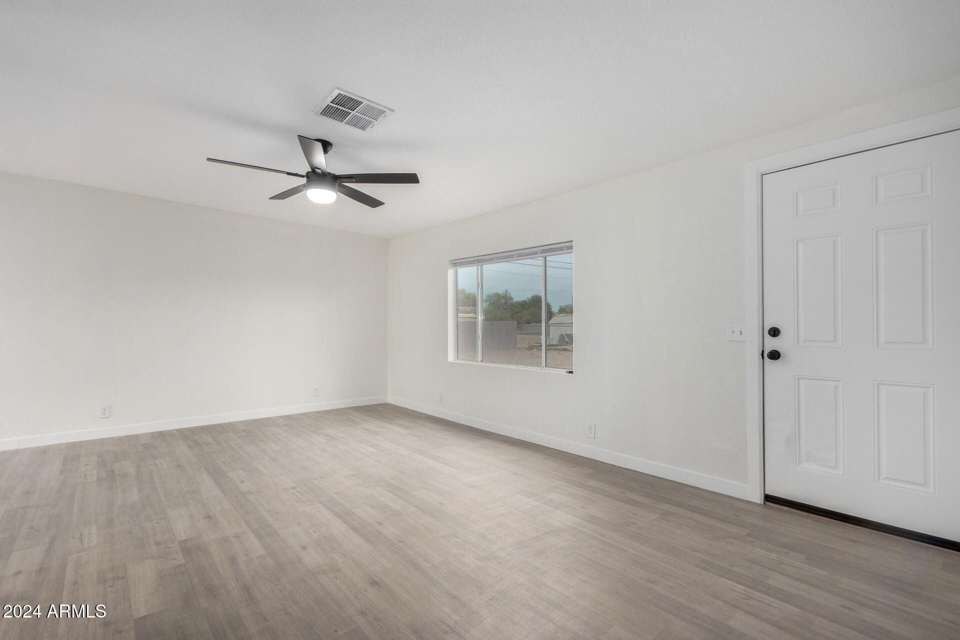 204 East Baseline Road Buckeye, AZ 85326 - Photo 3 of 29 a view of a room with a ceiling fan and wooden floor