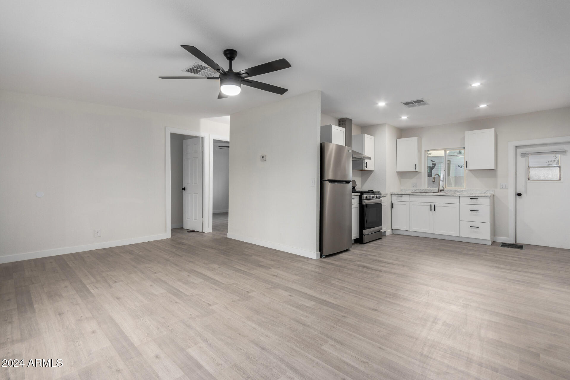 204 East Baseline Road Buckeye, AZ 85326 - Photo 7 of 29 a view of a kitchen with a sink and wooden floor