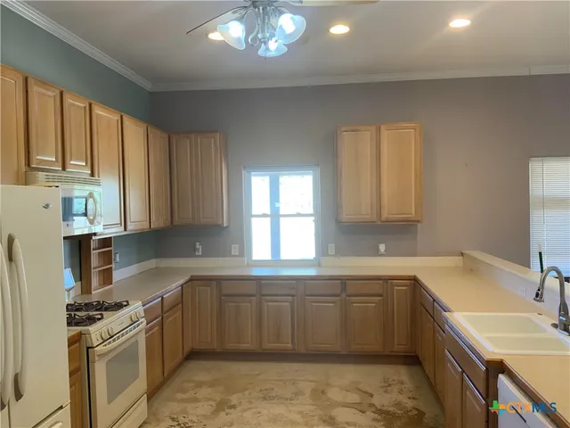 a hall with kitchen island a sink chandelier and fireplace