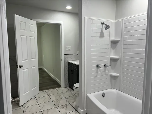 a view of a hallway with wooden floor and closet area