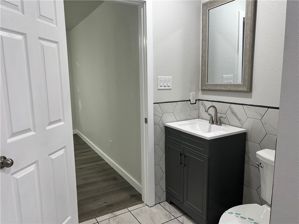 912 North Rife Street Aransas Pass, TX 78336 - Photo 13 of 23 a bathroom with a sink vanity mirror and toilet