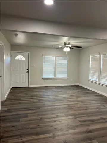 an empty room with a window and a fan