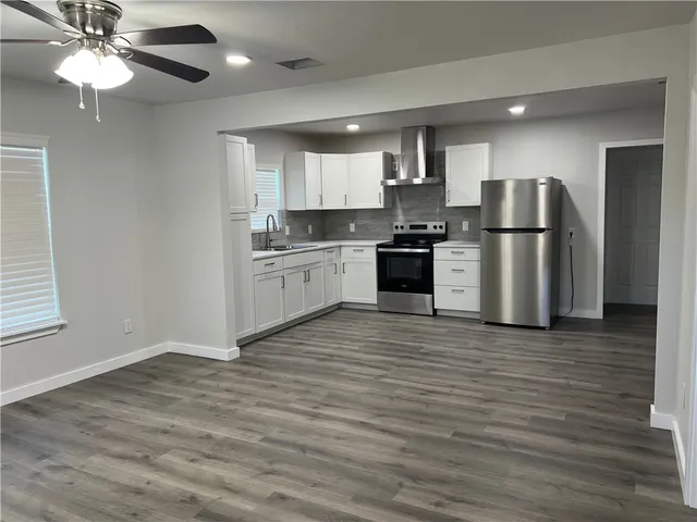 a kitchen with stainless steel appliances granite countertop a stove top oven a refrigerator a sink and a microwave