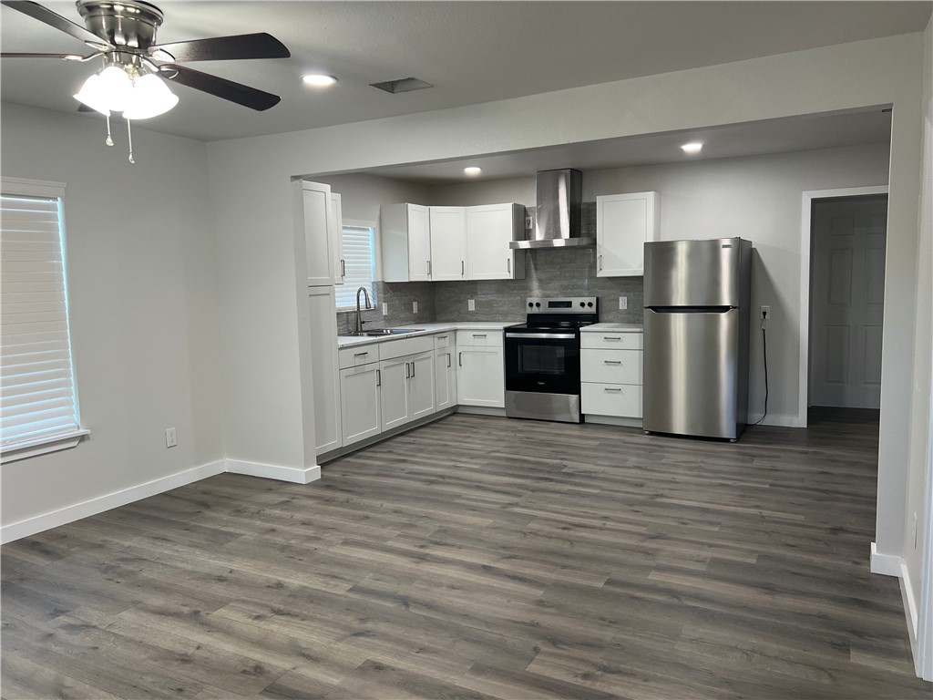 912 North Rife Street Aransas Pass, TX 78336 - Photo 3 of 23 a kitchen with stainless steel appliances granite countertop a stove top oven a refrigerator a sink and a microwave