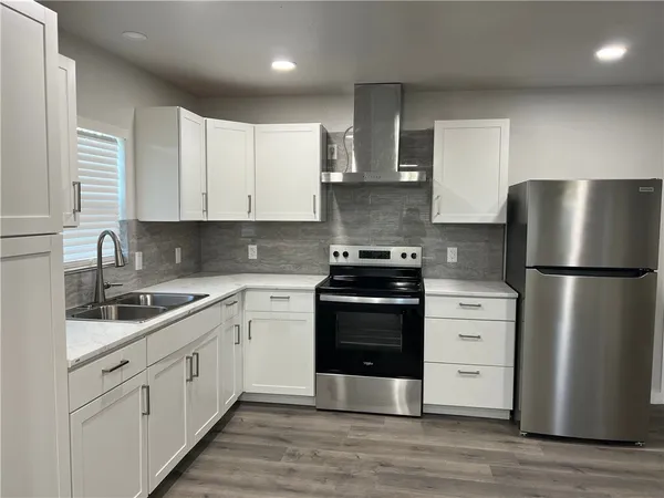 a kitchen with stainless steel appliances white cabinets and a refrigerator