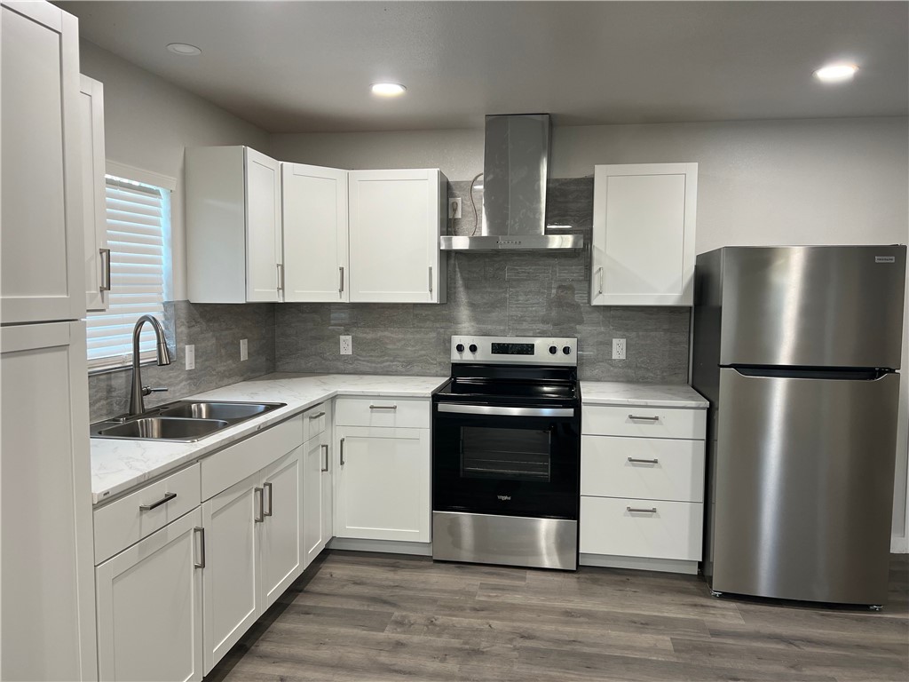 912 North Rife Street Aransas Pass, TX 78336 - Photo 5 of 23 a kitchen with stainless steel appliances white cabinets and a refrigerator