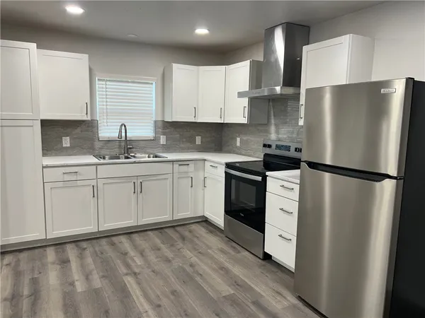 a view of a refrigerator in kitchen and wooden floor