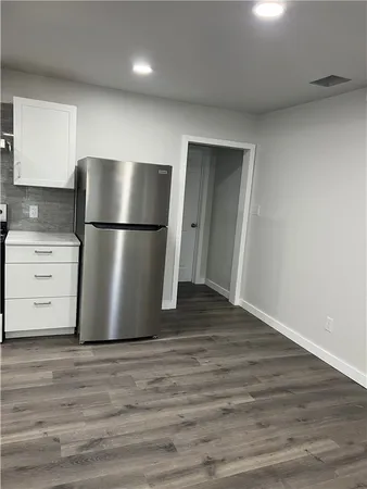 a view of a kitchen with a refrigerator a ceiling fan and wooden floor