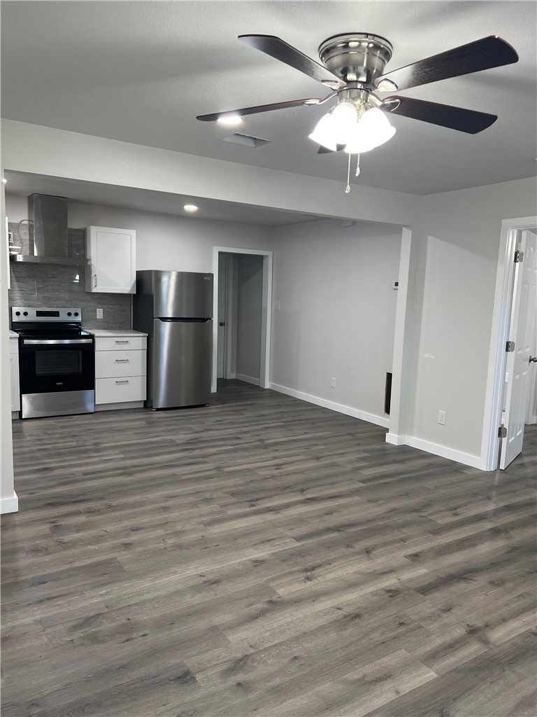 912 North Rife Street Aransas Pass, TX 78336 - Photo 9 of 23 a view of a kitchen with a refrigerator a ceiling fan and wooden floor