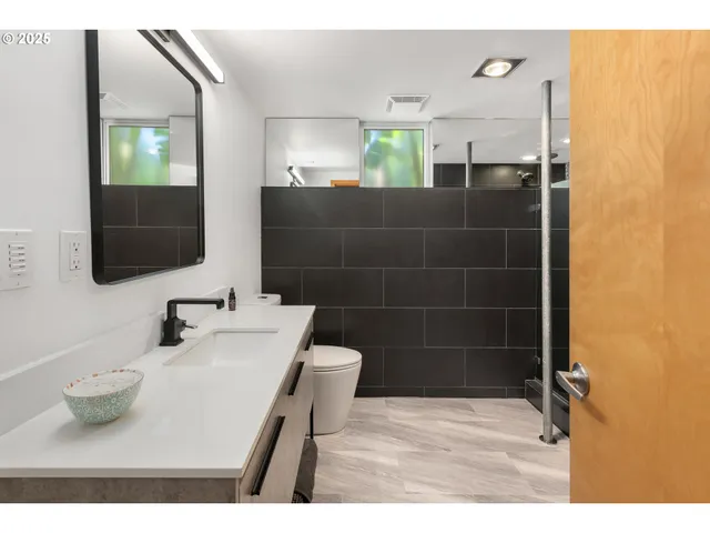 a bathroom with a sink a toilet and mirror