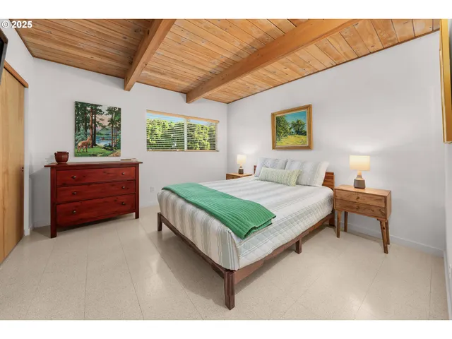 a bedroom with a bed dresser and a window