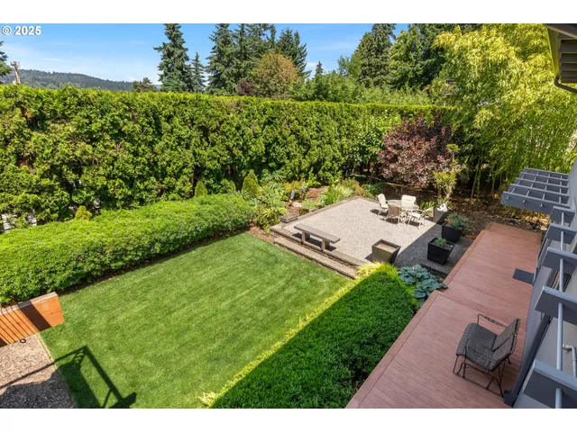 a view of a backyard with plants and lake view