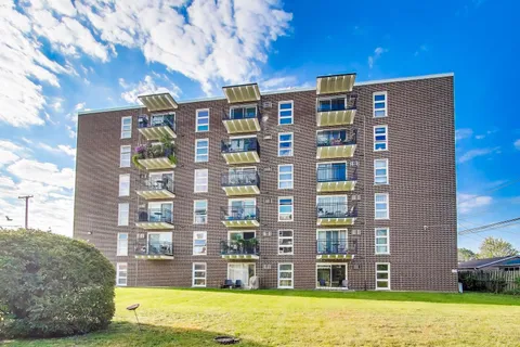 a front view of a building with a garden