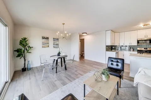 a living room with furniture and a dining table with kitchen view