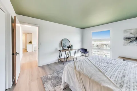 a bedroom with a bed and a large window