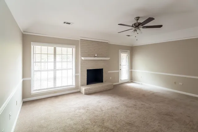 a view of an empty room with a window and fireplace