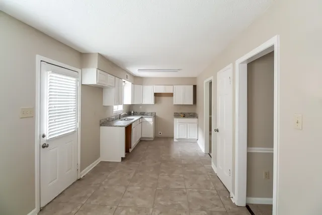 a kitchen with white cabinets and white appliances