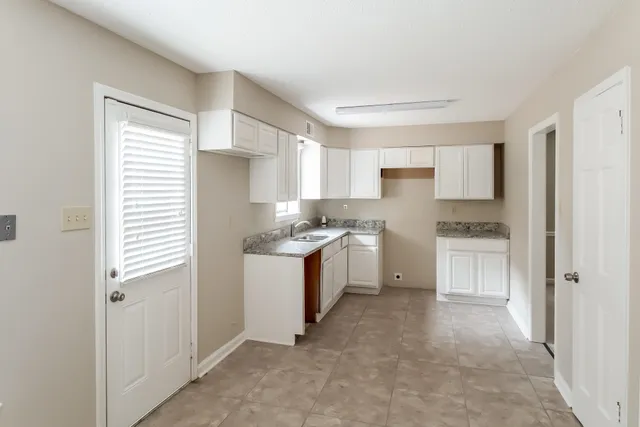a kitchen with white cabinets and white appliances