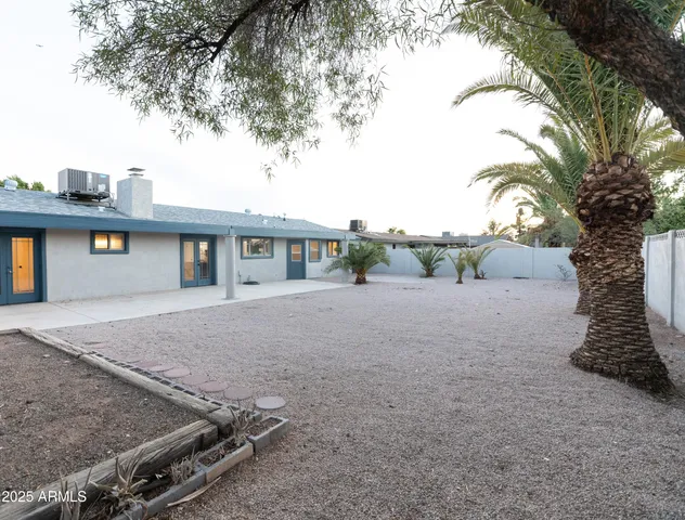 a view of a house with a yard and potted plants
