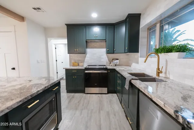 a kitchen with granite countertop stainless steel appliances and wooden cabinets