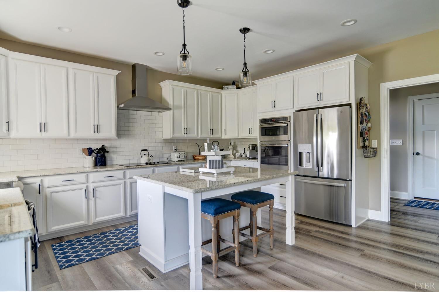 2667 Bellevue Road Forest, VA 24551 - Photo 19 of 55 a kitchen with stainless steel appliances granite countertop a refrigerator a sink dishwasher a stove and white cabinets with wooden floor