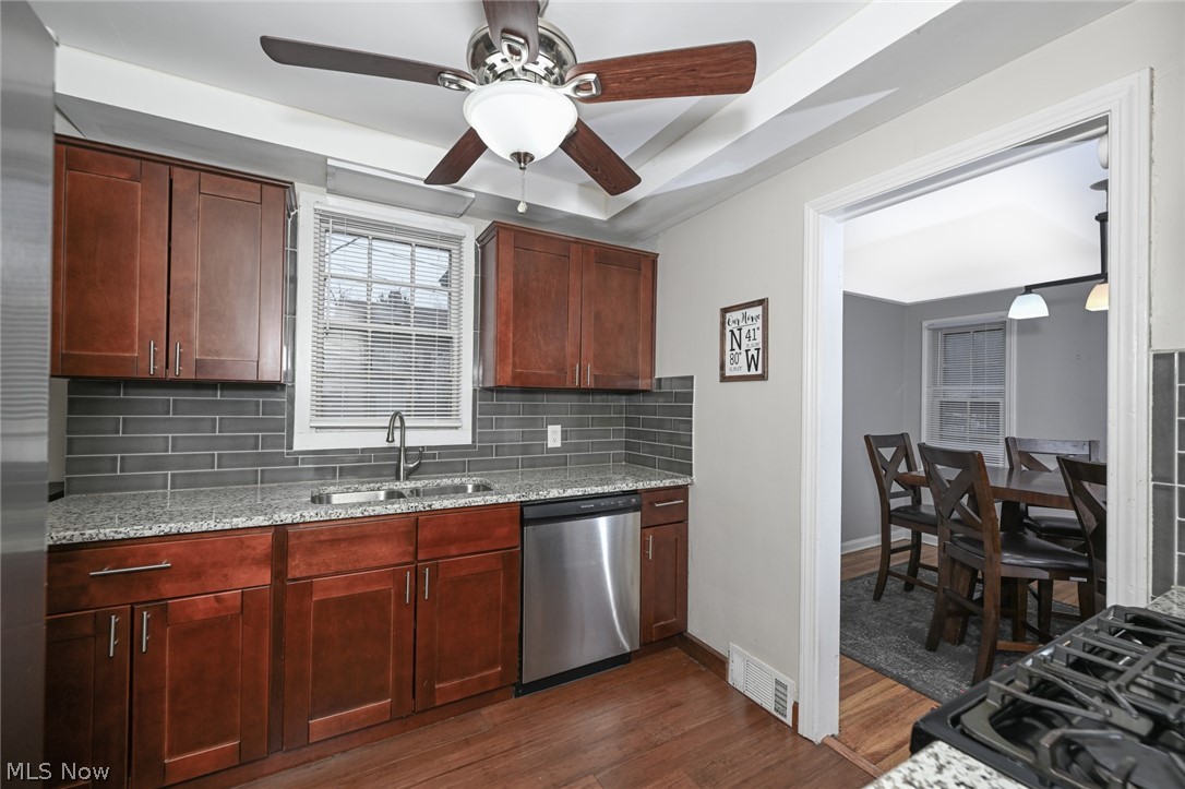 3699 Bainbridge Road Cleveland Heights, OH 44118 - Photo 14 of 37 Kitchen featuring warm wood cabinetry, light-toned countertops, and a gray subway tile backsplash