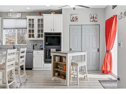 a living room with stainless steel appliances furniture and a kitchen view