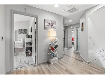 a view of a hallway with wooden floor and workspace