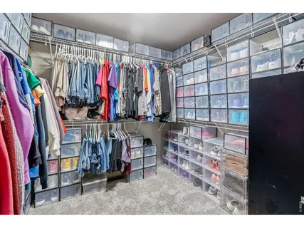 a view of walk in closet with clothes and shoes