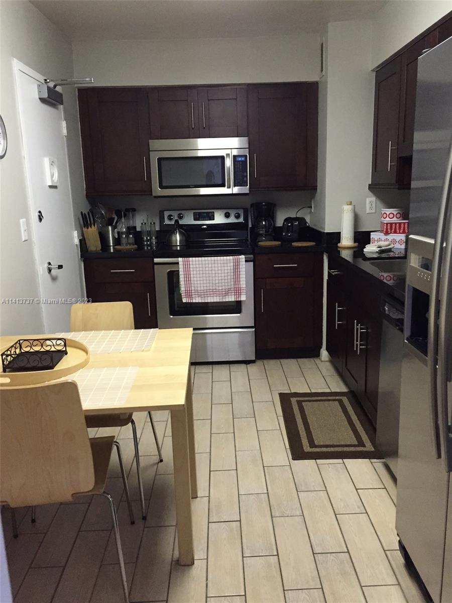 Surfside Surfside, FL 33154 - Photo 6 of 27 a kitchen with stainless steel appliances kitchen island granite countertop a refrigerator and a stove top oven