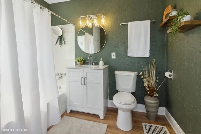 a bathroom with a toilet sink vanity and mirror