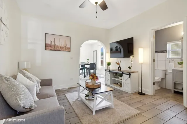 a living room with furniture a flat screen tv and kitchen view