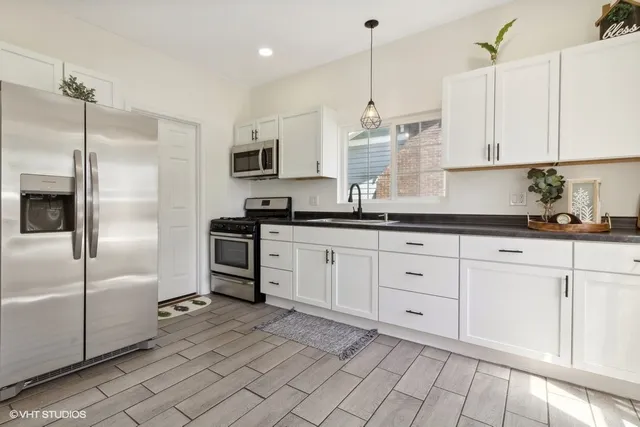 a kitchen with white cabinets and stainless steel appliances