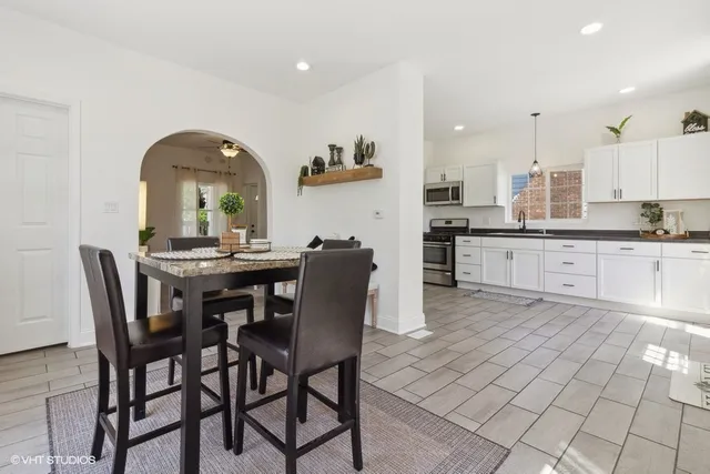 a kitchen with stainless steel appliances granite countertop a table and chairs in it