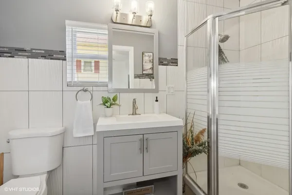 a bathroom with a sink a toilet and shower