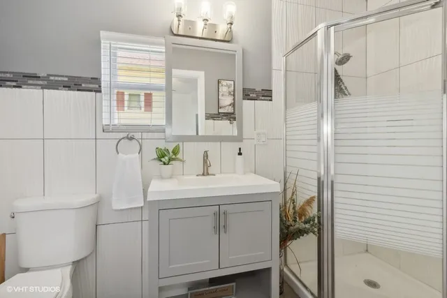 a bathroom with a sink a toilet and shower