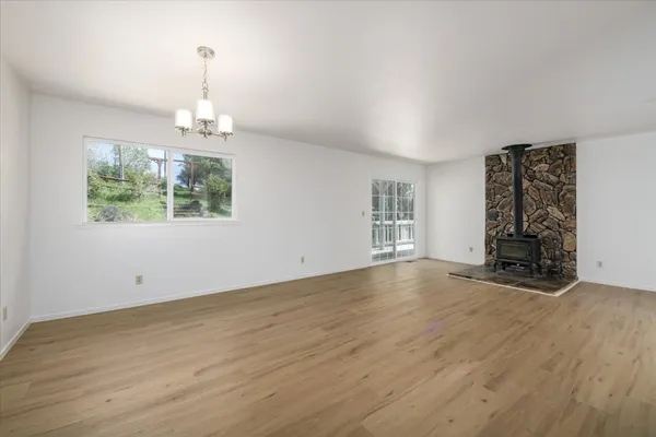 an empty room with wooden floor a ceiling fan and a window