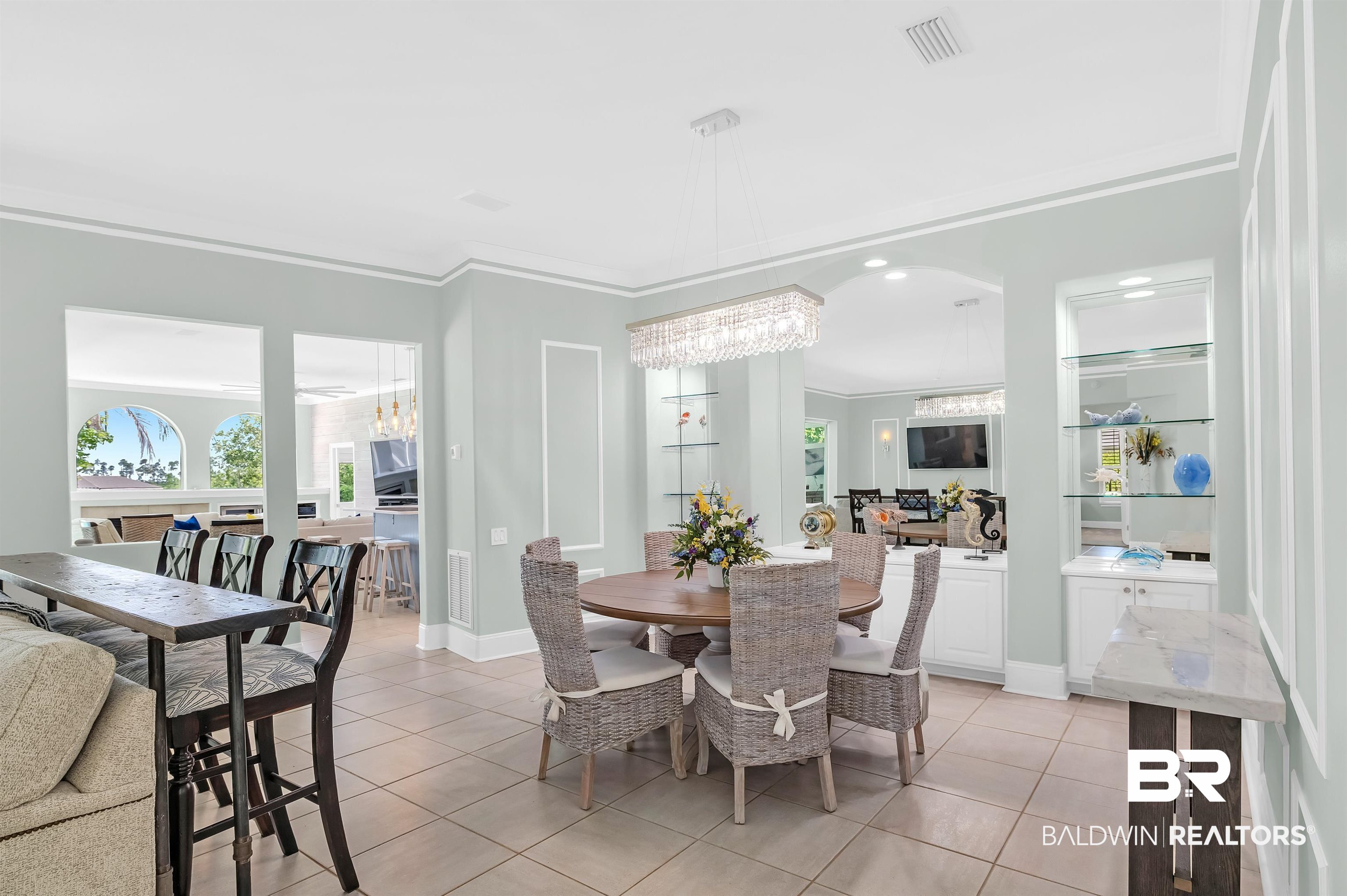 8160 Bay View Drive Foley, AL 36535 - Photo 15 of 43 Dining space featuring light tile patterned flooring, a chandelier, ornamental molding, and baseboards