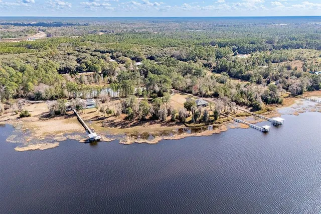 an aerial view of ocean and residential houses with outdoor space