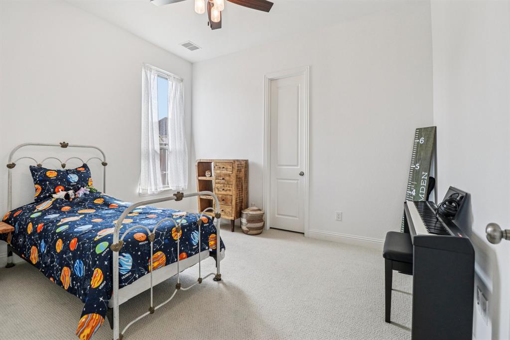 8277 Halifax The Colony, TX 75056 - Photo 25 of 37 a bedroom with a bed and wooden floor