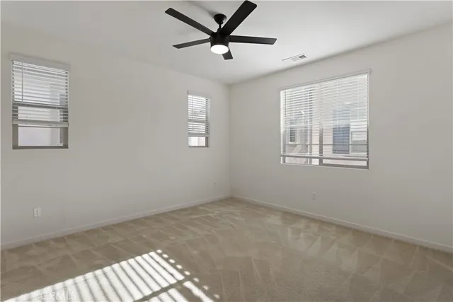 an empty room with a window and a ceiling fan