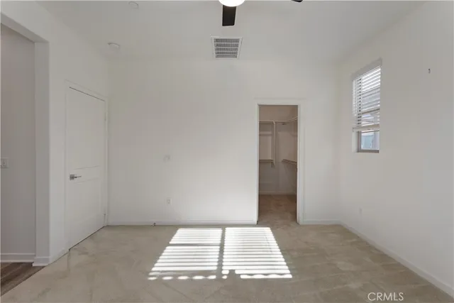 an empty room with a window and a ceiling fan