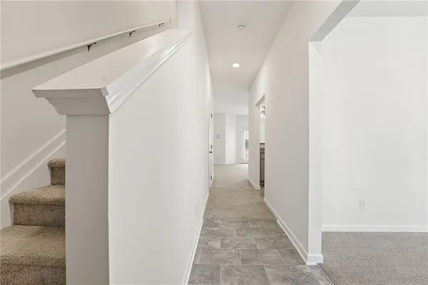 a view of a hallway with white walls and entryway
