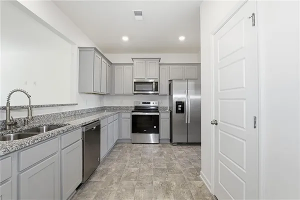 a kitchen with a refrigerator sink and cabinets