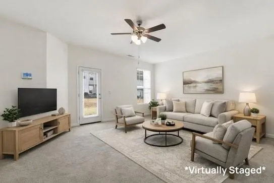 a living room with furniture a flat screen tv and a window